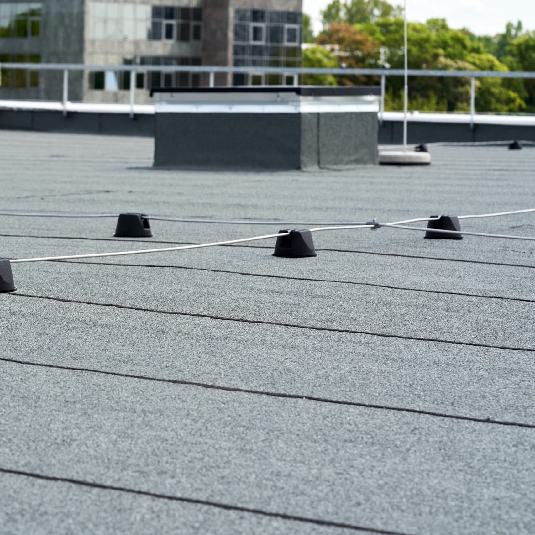 Flat roof covered with bitumen membrane for waterproofing.